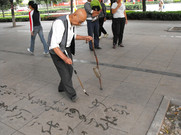 一位老年人在公園寫字